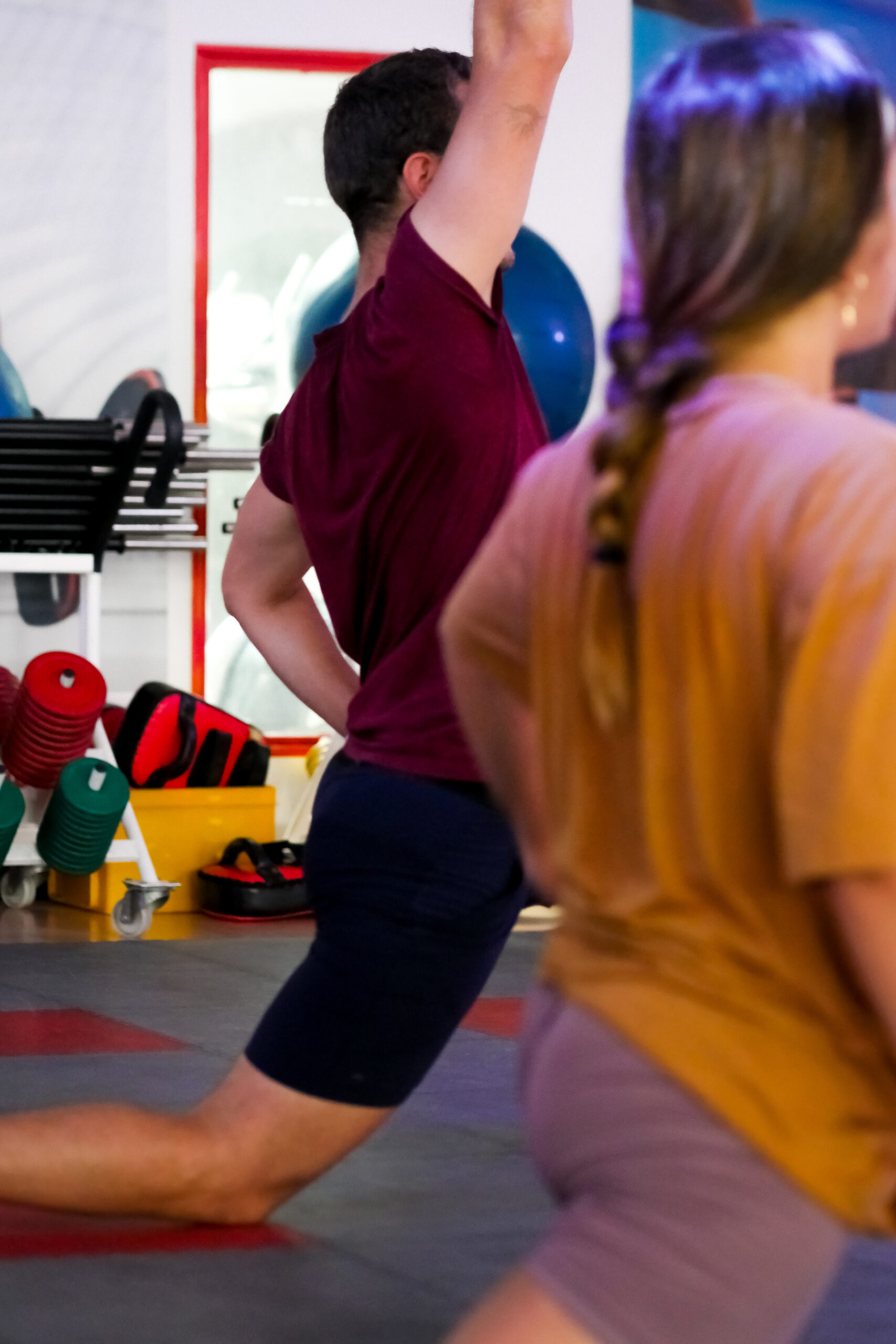 coach sportif montre un mouvement à une adhérente lors d'un cours de bodystretch